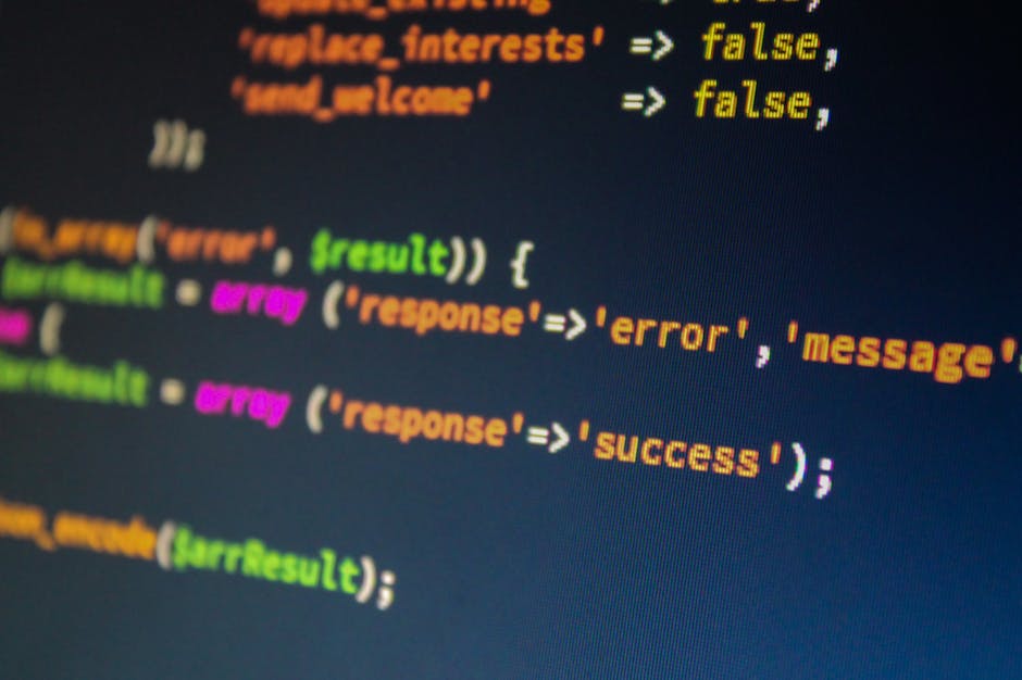 Close-up image of a computer monitor displaying lines of colorful programming code, including keywords like 'false', 'error', 'message', and 'success' in bright green, orange, pink, and yellow text on
